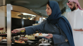 سيدة سعودية تقوم بطهي الطعام